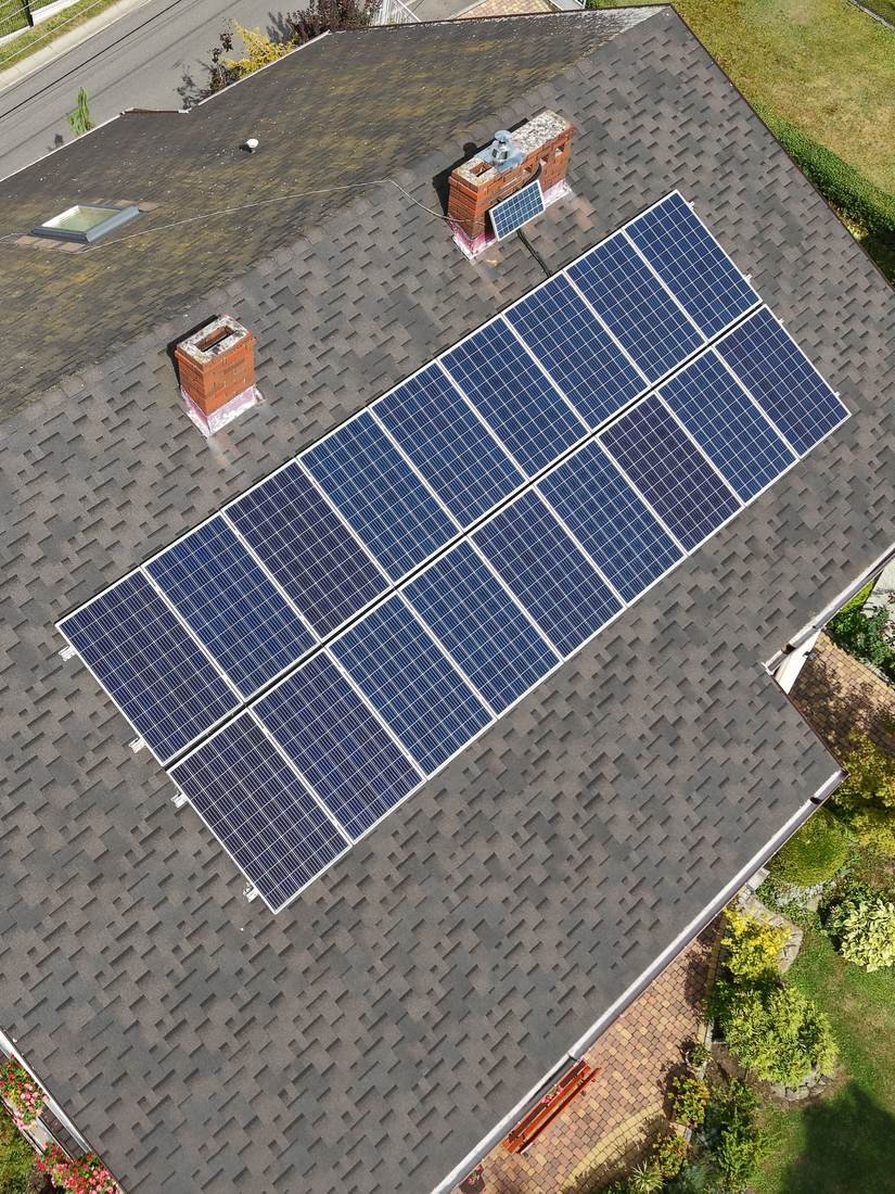 Aerial overview photo of a house roof, chimneys, solar panels and garden